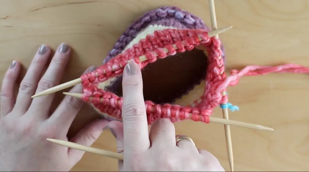 Hands holding knitted nest on Double Pointed Knitting Needles