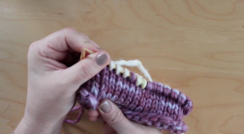 Hands holding purple knitted nest