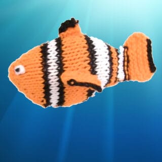 Knitted Fish Finding Nemo Clown in orange, white, and black yarn colors.