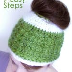 A woman wearing a knitted messy bun hat in green and white yarn colors
