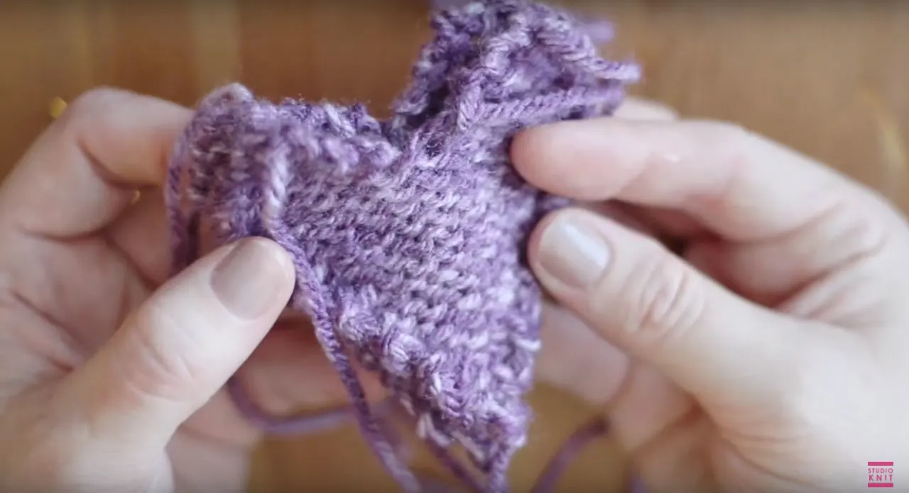 Putting knitted hearts together with the wrong sides on the outside.
