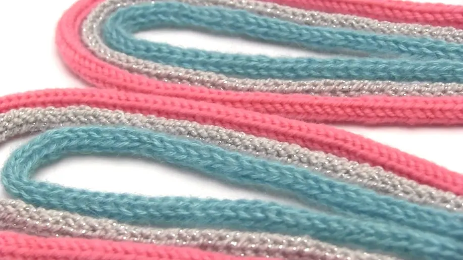 Rows of knitted i-Cords in blue, pink, and silver yarn colors.