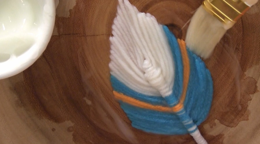 A close up of a fiber feather with paint brush.