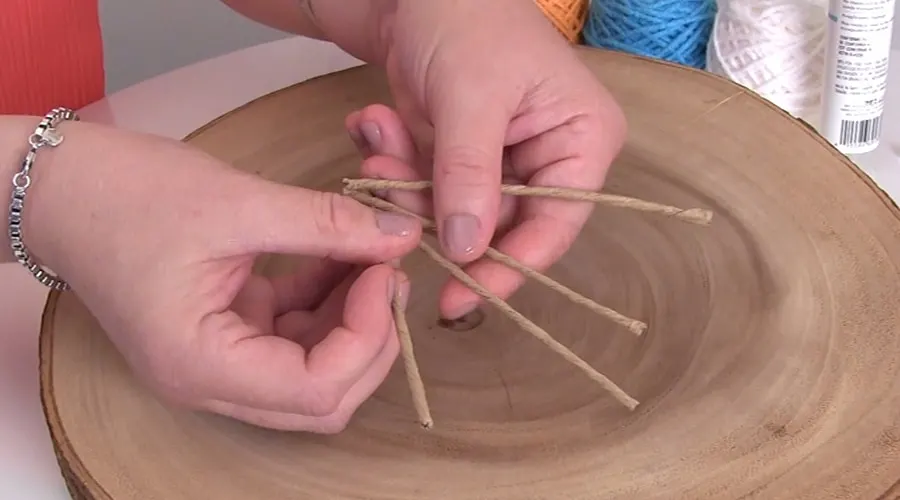 Hands holding pieces of paper wrapped craft wire.