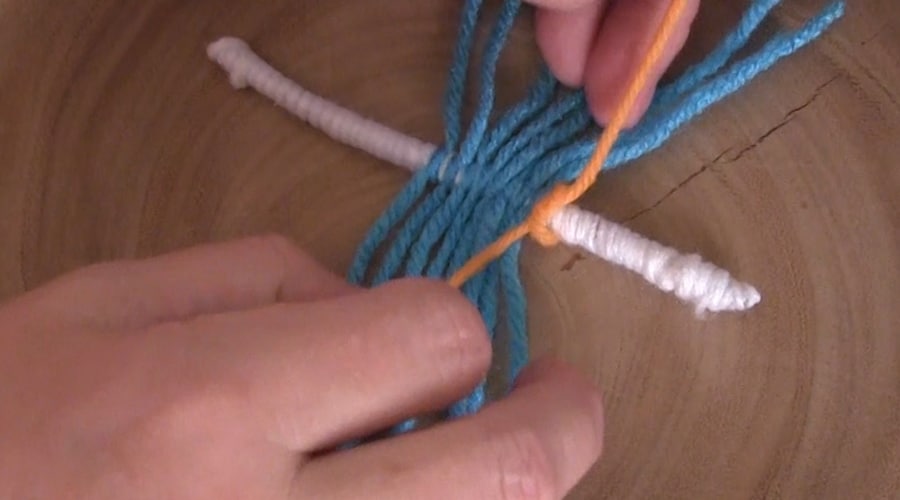 Tying yarn around craft wire.