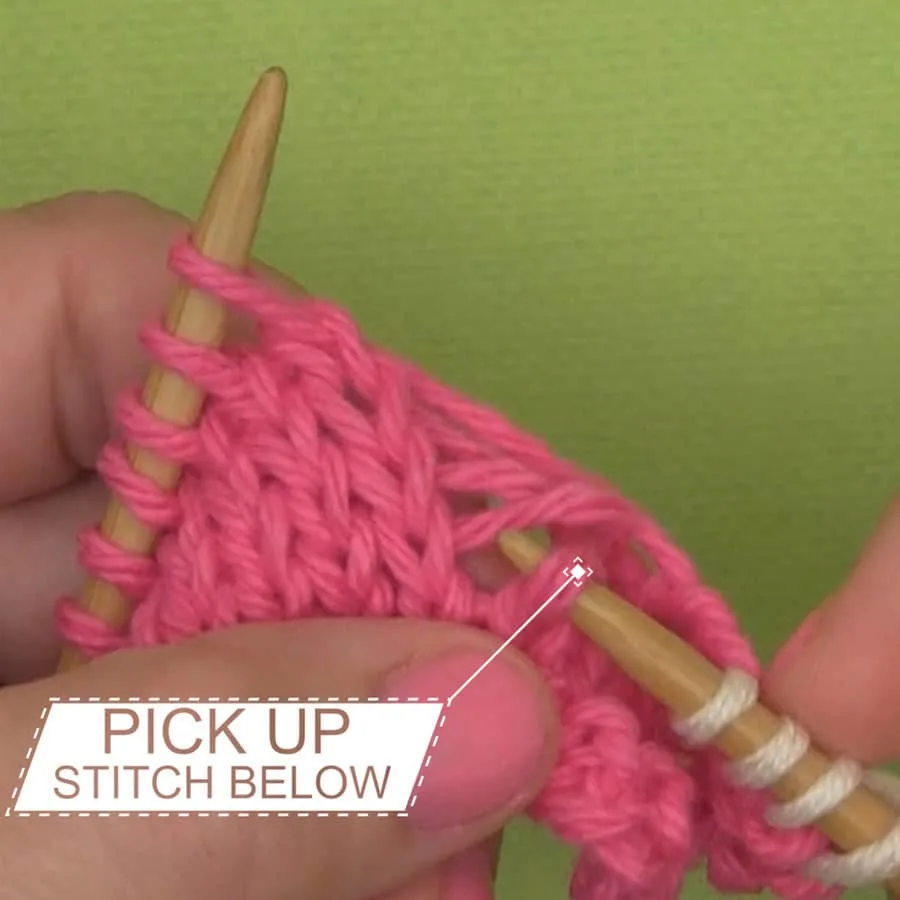 Picking up the dropped stitch with a knitting needle.