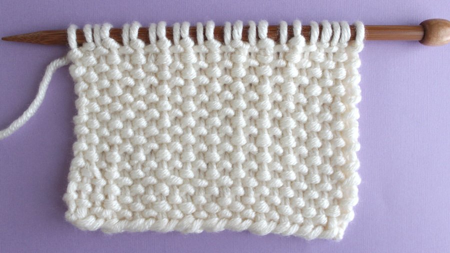 Wrong side of the Linen Stitch in white color yarn on bamboo knitting needle.