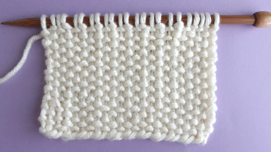 Wrong side of the Linen Stitch in white color yarn on bamboo knitting needle.