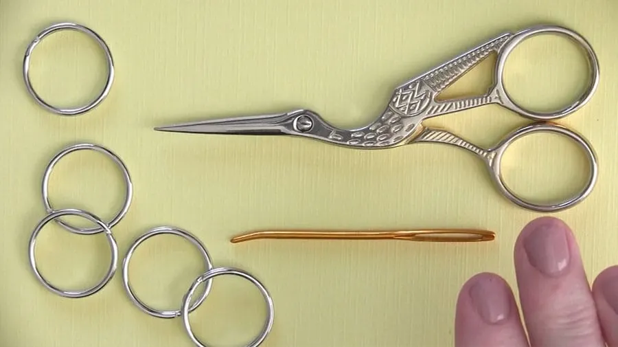 Stork crane scissors, key rings, and a tapestry needle.
