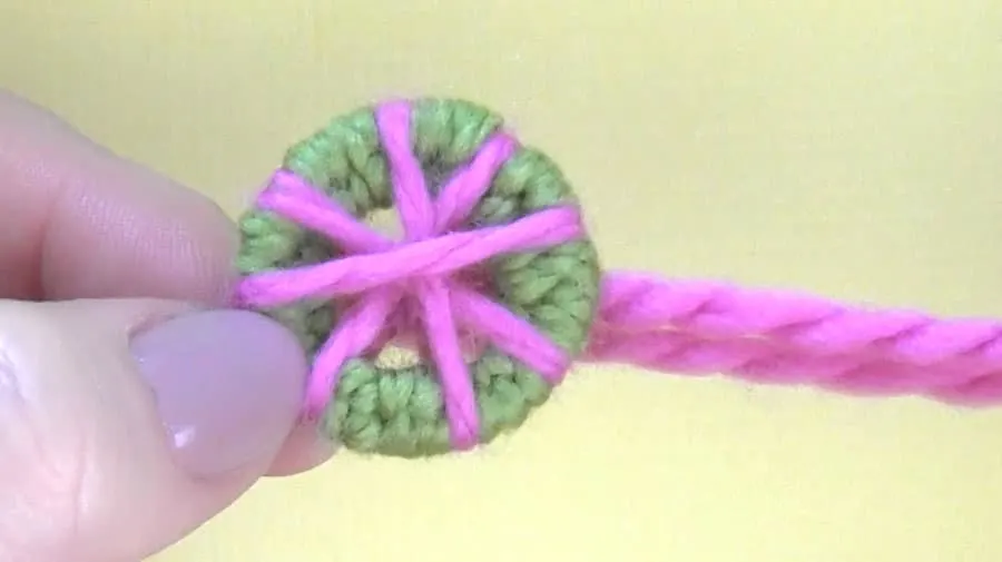 Wrapping yarn around a key ring to make a dorset button.