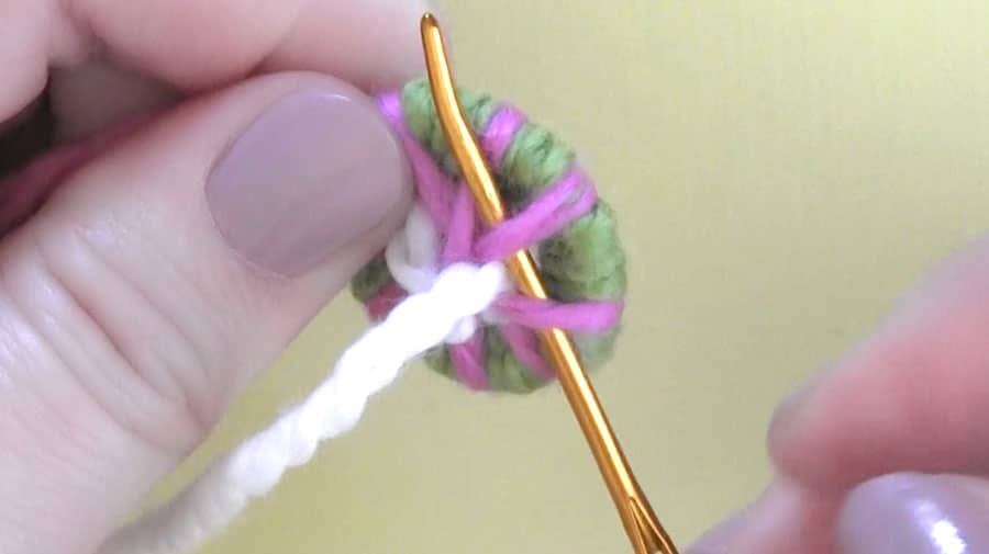 Using a tapestry needle to weave yarn into a dorset button.