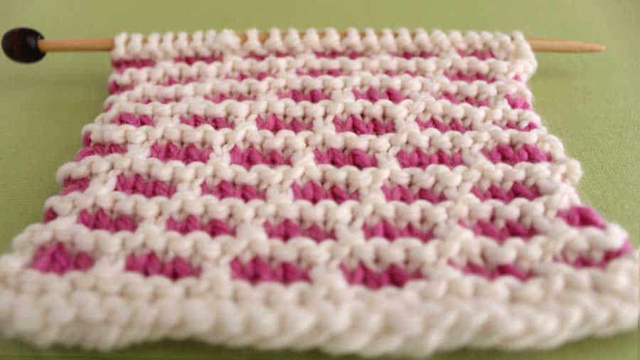 A close up of the Brick Stitch with pink and white yarn.