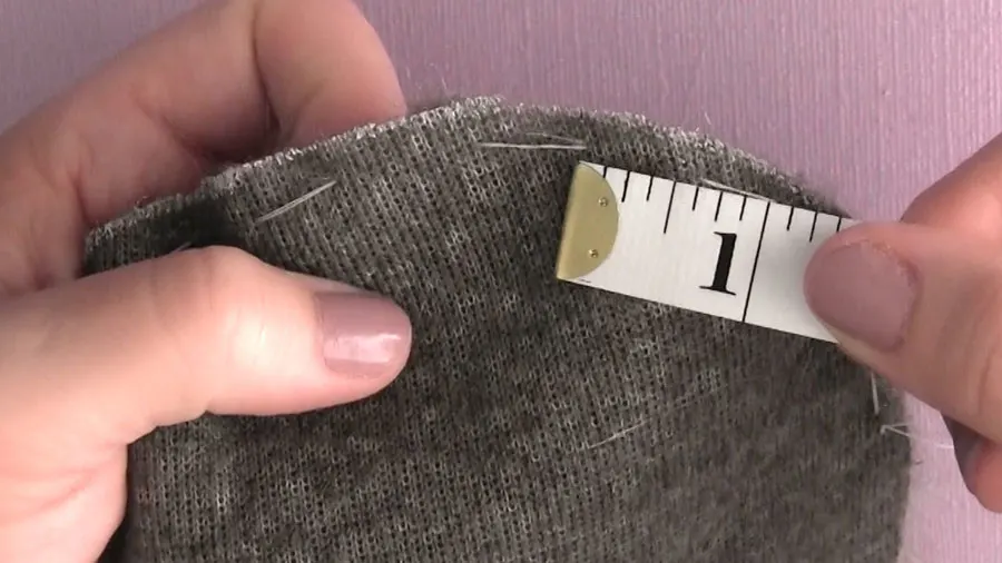 Ruler showing one inch between sewing stitches on faux fur.