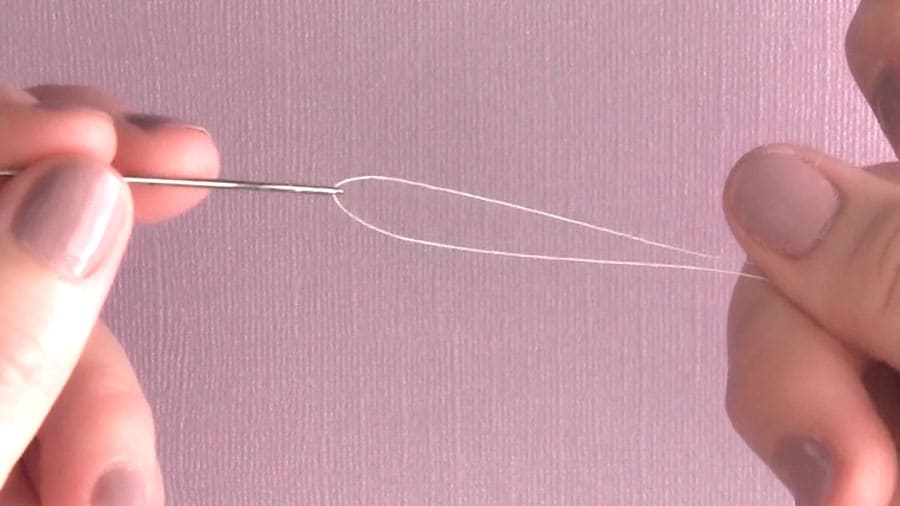 Threading a sewing needle.