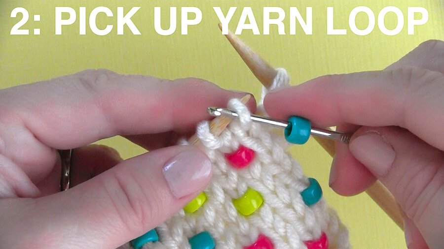 Demonstrating how to pick up yarn with a crochet needle.