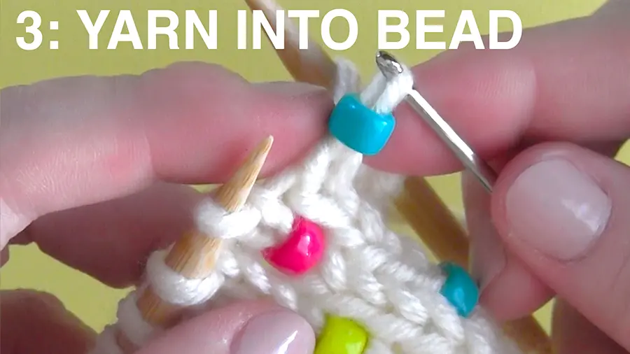 Knitting with beads by using a crochet hook to pick up stitch.