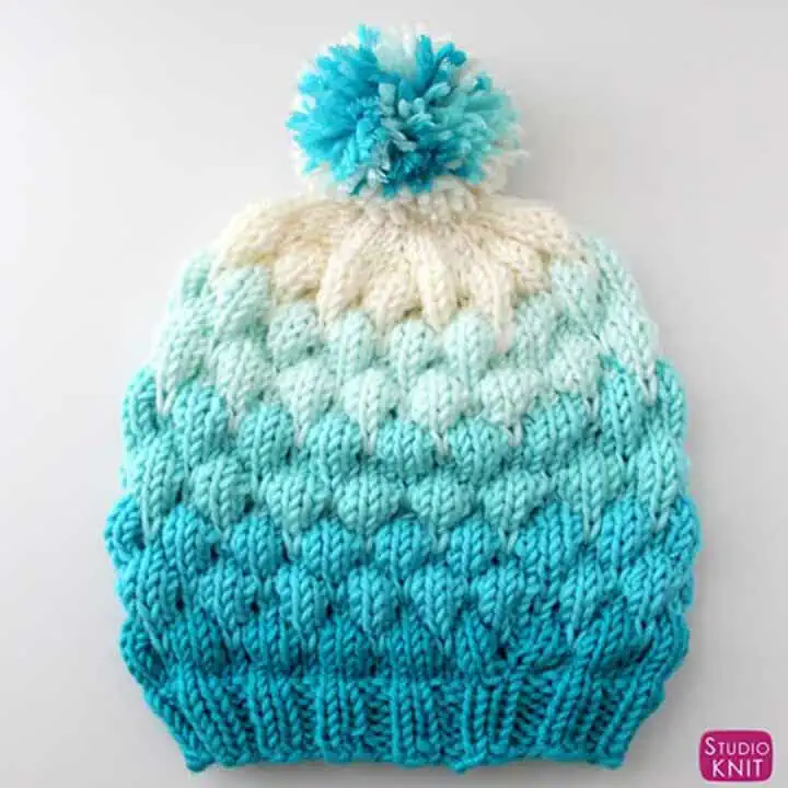 Knitted Bubble Beanie Hat in shades of blue yarn color with pom pom.