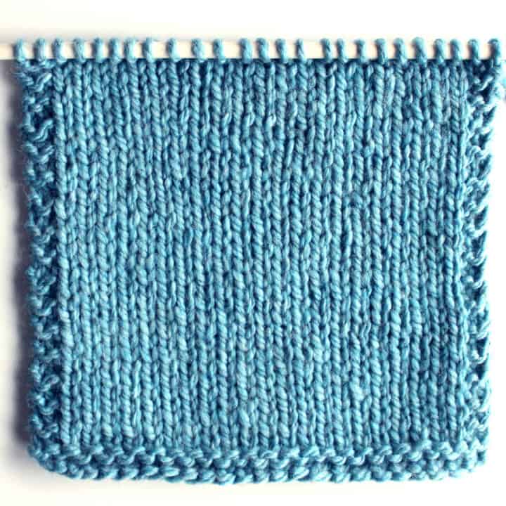 Stockinette Knit Stitch Pattern in blue color yarn on needle.