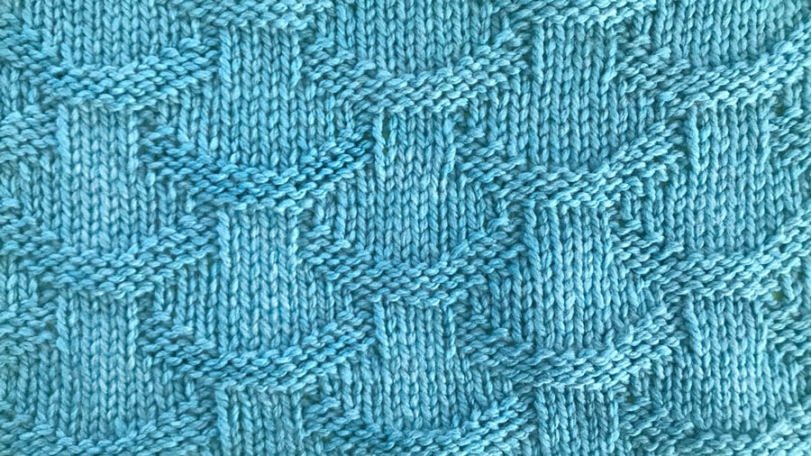 Close up a swatch of textured Basket Loop Stich in blue yarn
