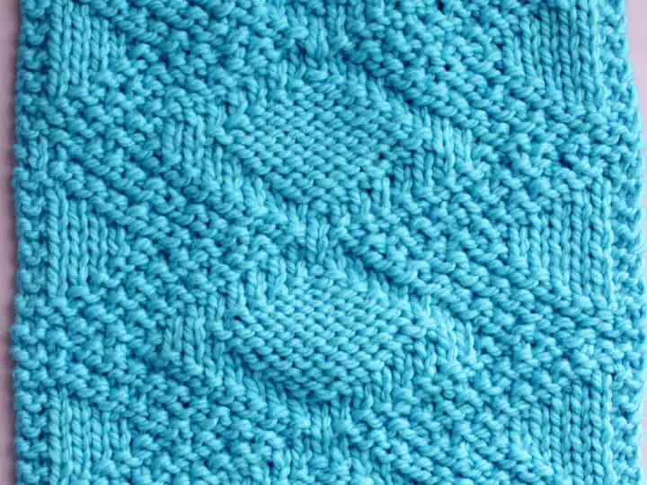 Knitted Swatch of the Fancy Diamond Knit Stitch Pattern texture in blue color yarn on a straight knitting needle.