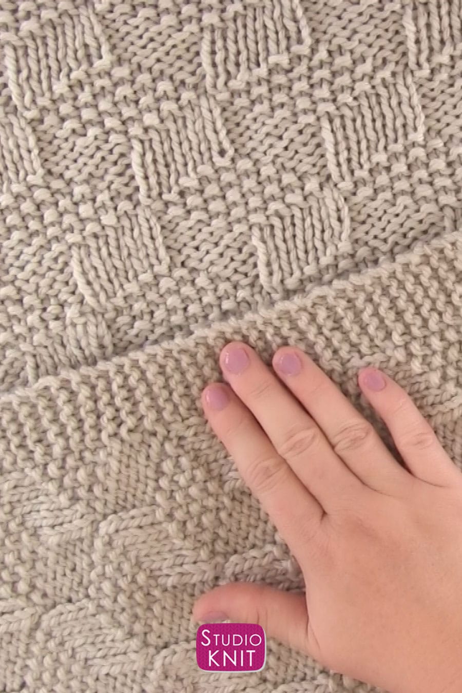 Knitted Blanket in Tumbling Moss Blocks Stitch draped with hand