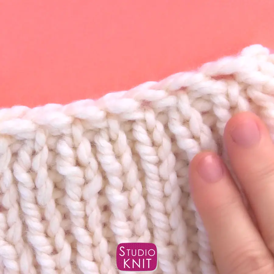 Hand and knitted swatch demonstrating the Two-Row Bind Off technique