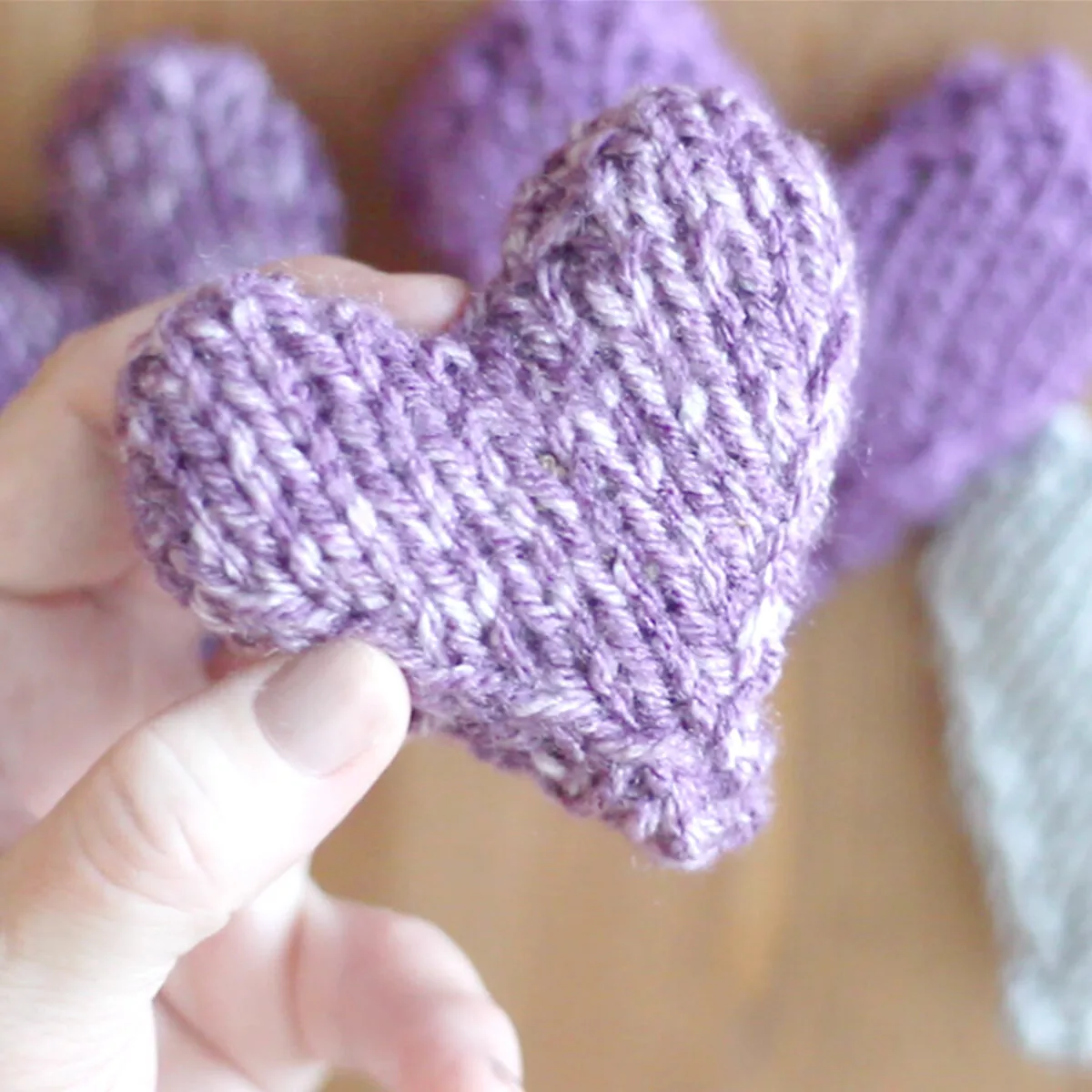 puffy stuffed knitted heart with hand holding