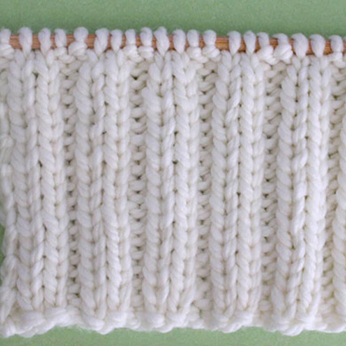 2x2 Rib Stitch Knitting Pattern in white yarn on knitting needle