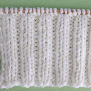 2x2 Rib Stitch Knitting Pattern in white yarn on knitting needle