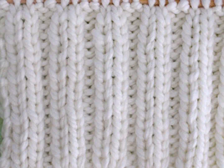 2x2 Rib Stitch Knitting Pattern in white yarn on knitting needle