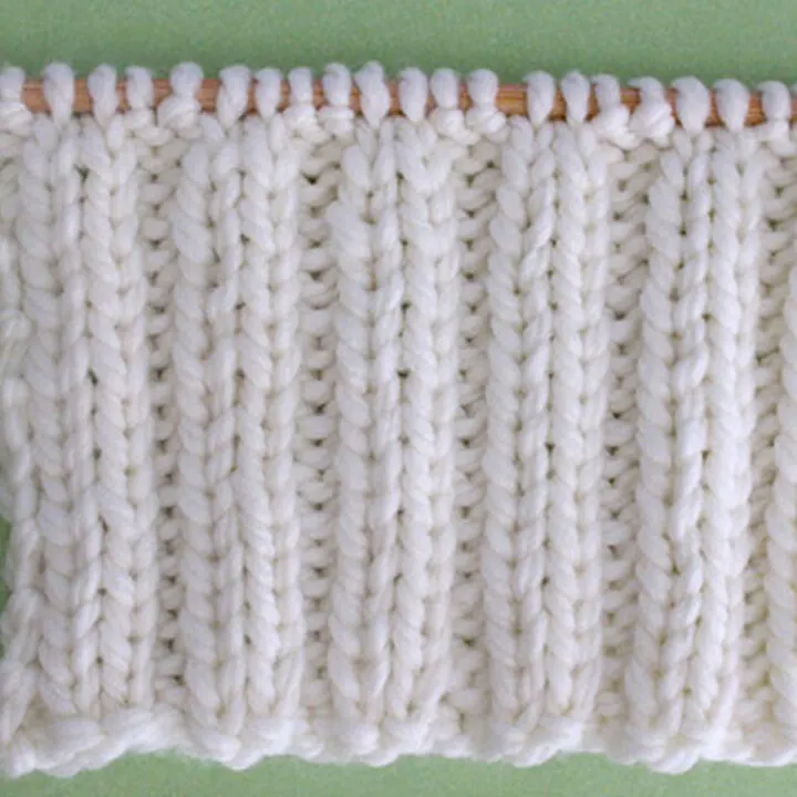 2x2 Rib Stitch Knitting Pattern in white yarn on knitting needle