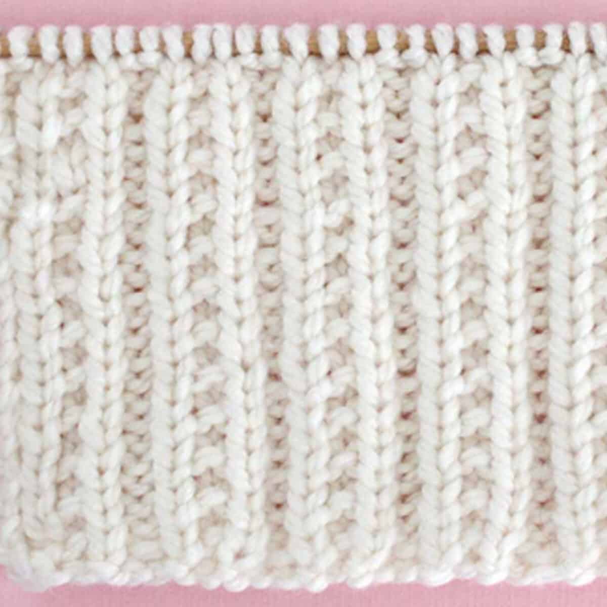 Beaded Rib Knit Stitch Pattern in white color yarn on knitting needle.