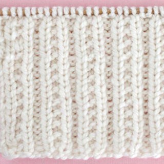 Beaded Rib Knit Stitch Pattern in white color yarn on knitting needle.