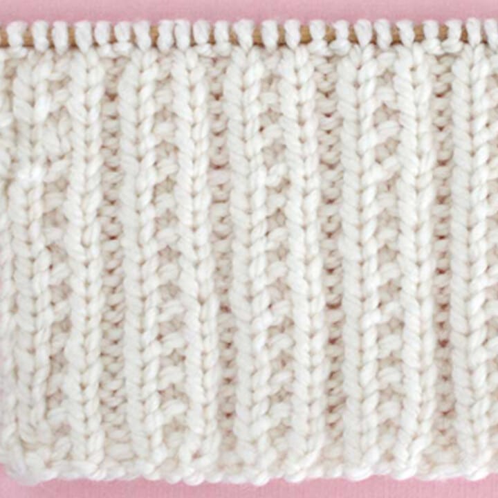 Beaded Rib Knit Stitch Pattern in white color yarn on knitting needle.