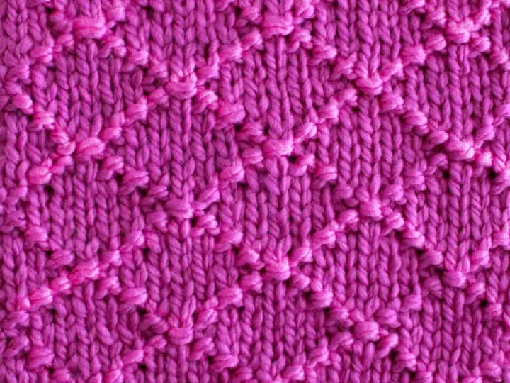 Diamond Brocade Knit Stitch Pattern texture in purple color yarn.