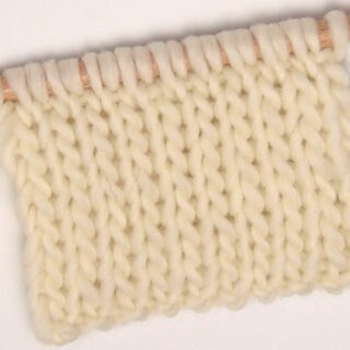 Double Stockinette Knit Stitch Pattern in white color yarn on knitting needle.
