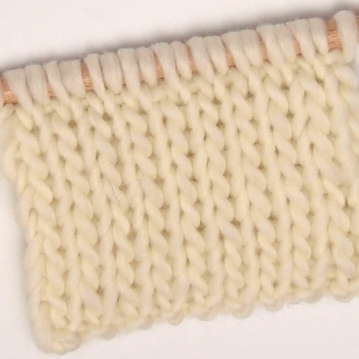 Double Stockinette Knit Stitch Pattern in white color yarn on knitting needle.