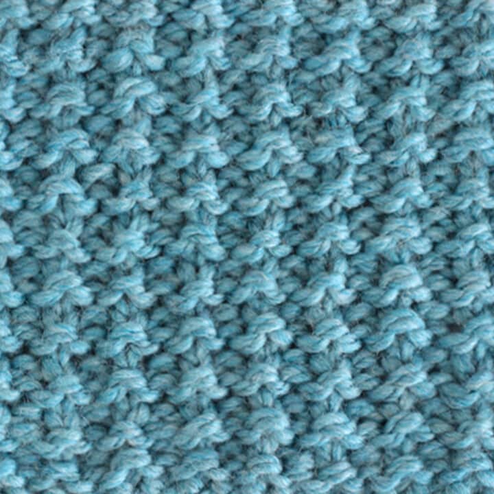 Sand Knit Stitch Pattern texture in blue yarn.
