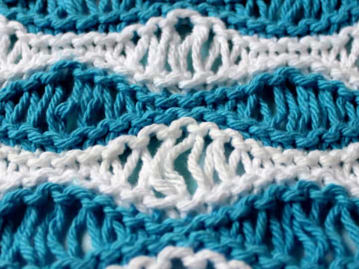 Knitted swatch in Sea Foam Wave pattern in horizontal stripes of blue and white color yarn.