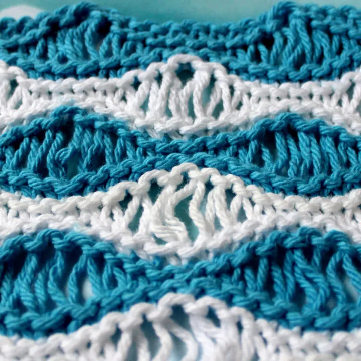 Knitted swatch in Sea Foam Wave pattern in horizontal stripes of blue and white color yarn.