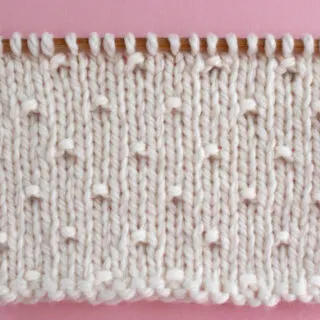 Simple Seed Knit Stitch Pattern in white yarn color on knitting needle.