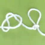 White yarn demonstrating the Slip Knot technique atop a green background.