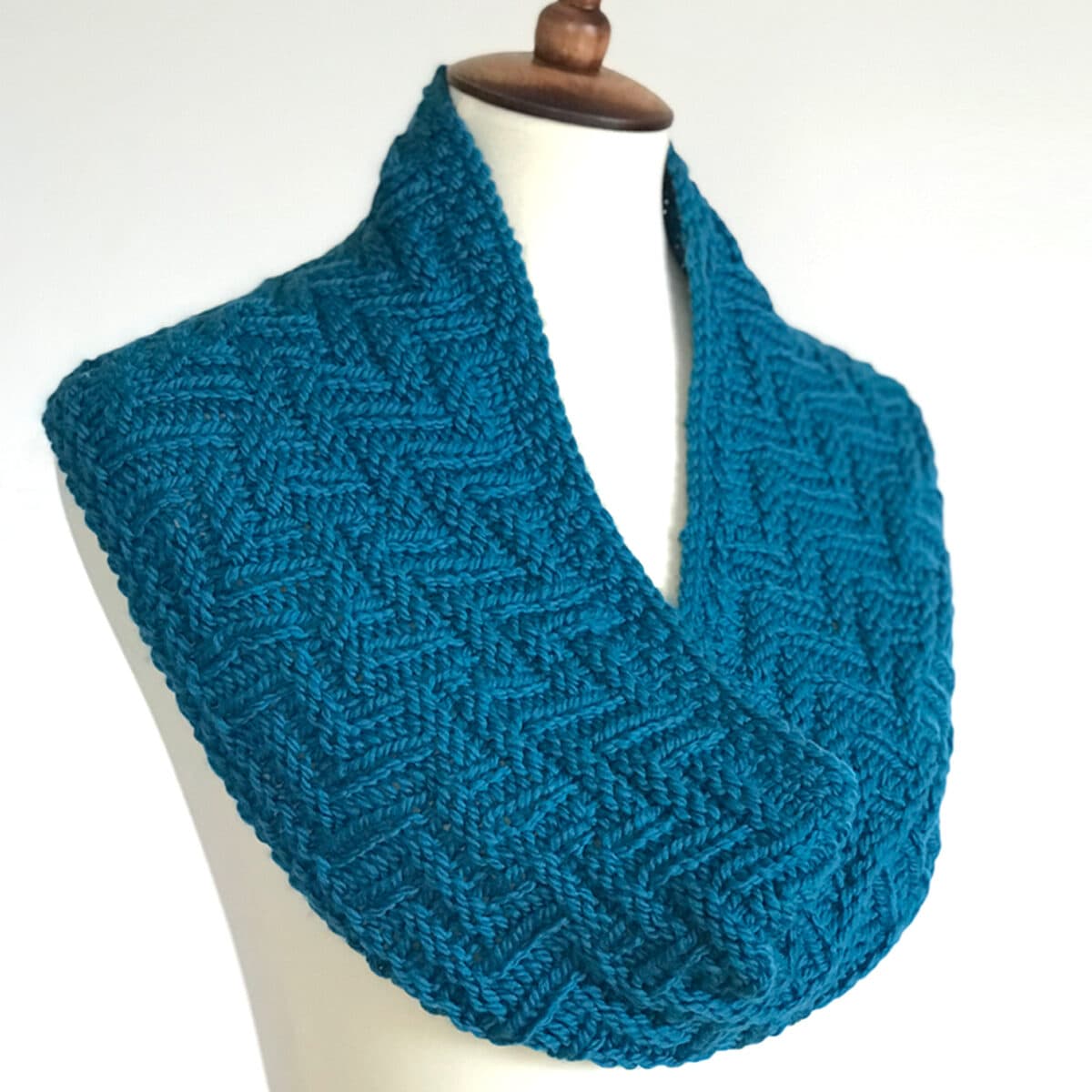 Knitted Scarf in Chevron Zigzag Knit Stitch Pattern texture with blue yarn color on dress form.