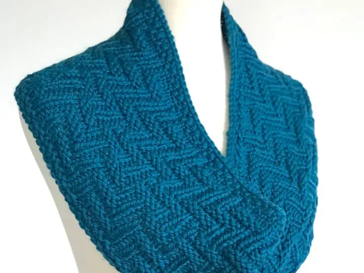 Knitted Scarf in Chevron Zigzag Knit Stitch Pattern texture with blue yarn color on dress form.