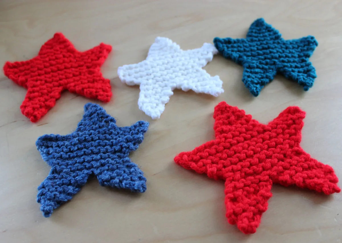 5 knitted star shapes in red, white, and blue yarn colors.