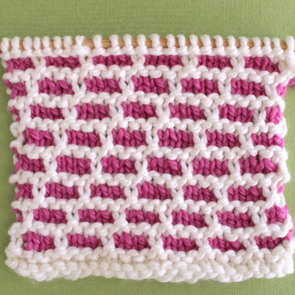 Brick Stitch Knitting pattern swatch in pink and white yarn colors.