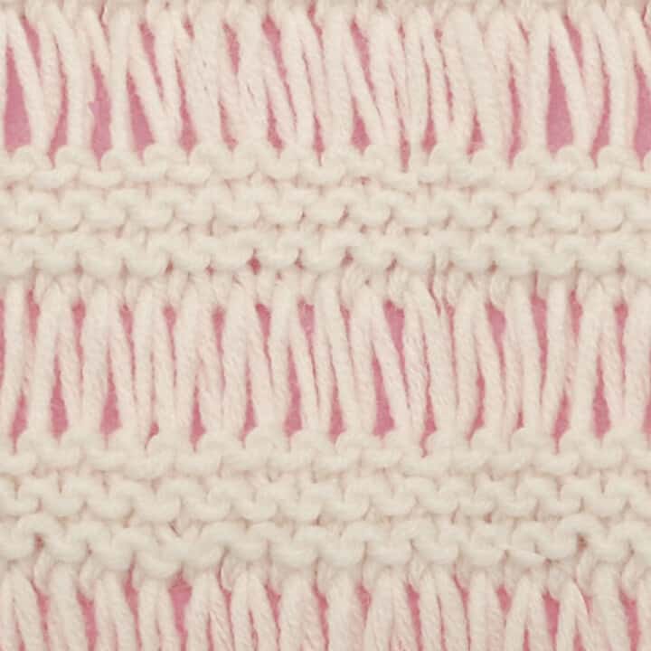 Drop Stitch Knitting Pattern texture in white color yarn atop pink background.
