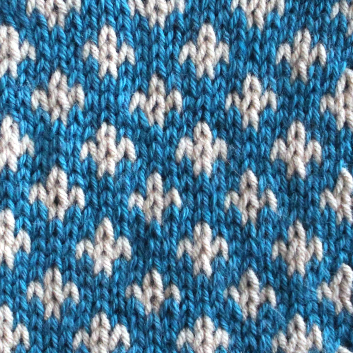 Fleur De Lys Stitch Knitting Pattern texture in blue and white colors of yarn.