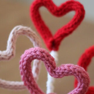 Knitted heart shaped i-cords in pink, red, and white yarn colors.