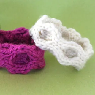 Knitted bracelets in honeycomb stitch texture with pink and white yarn colors atop a green background.